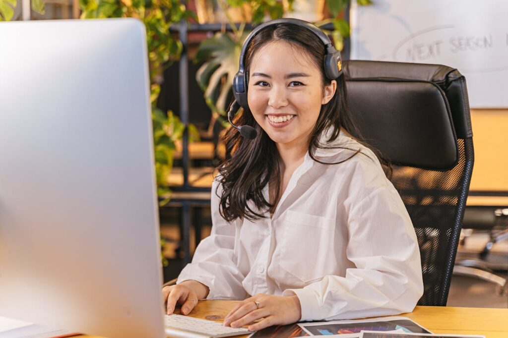 Woman in White Shirt Sitting in Front of a Computer